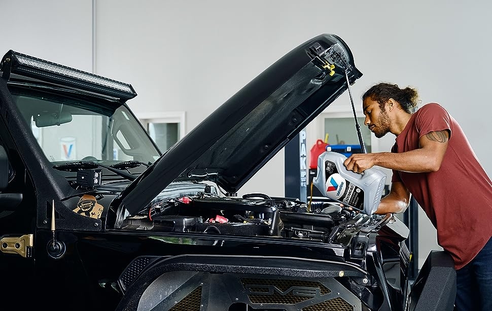 advanced full synthetic motor oil by valvoline being poured into a jeep engine